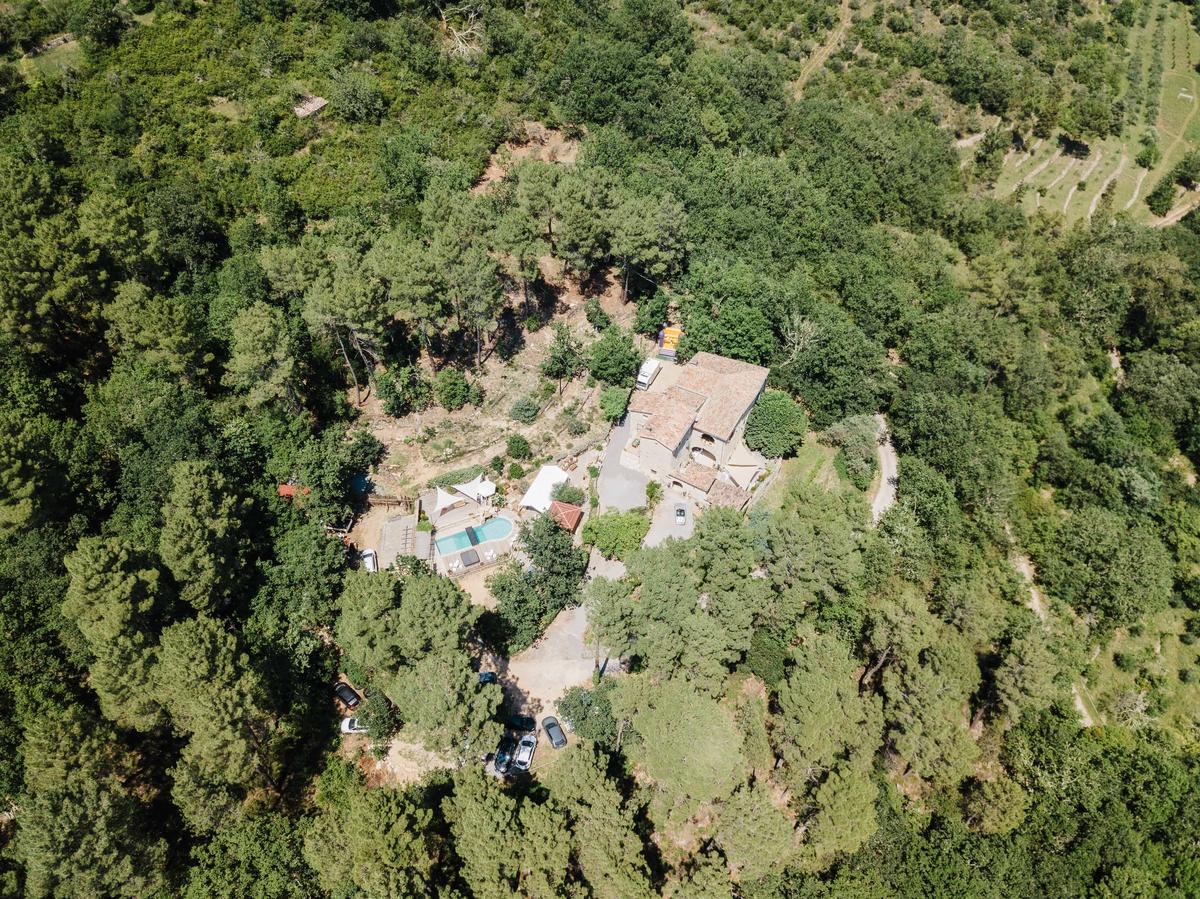 Vue aérienne du mas Les Fourches isolé dans la forêt ardéchoise