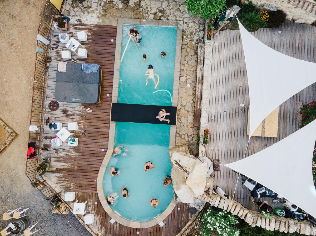 Piscine, voiles d'ombrage et baigneurs vus du ciel