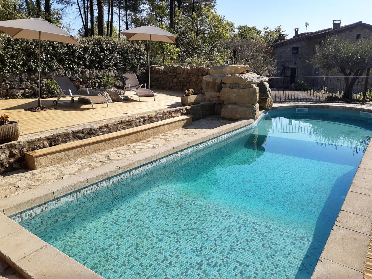 Piscine en mosaïque verte, parasols et oliviers