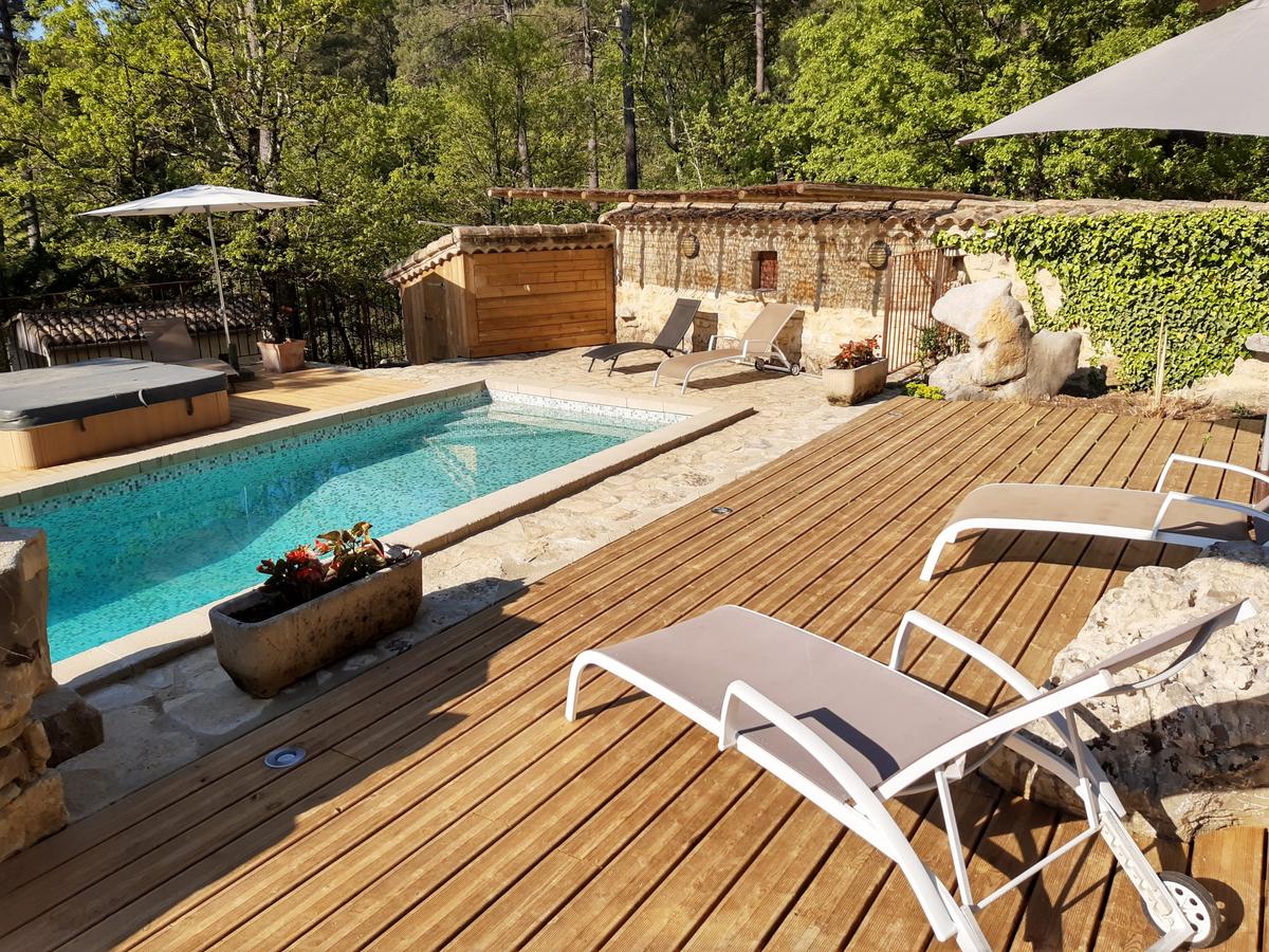 Piscine, spa et large terrasse en bois sous parasols
